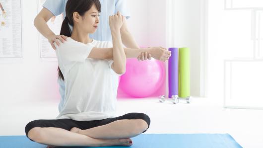 Physical therapist refines yoga stretch for patient