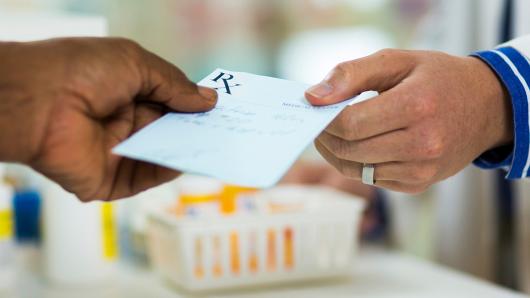 Patient handing medical professional a prescription