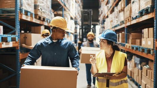 Warehouse employees stocking shelves and interacting