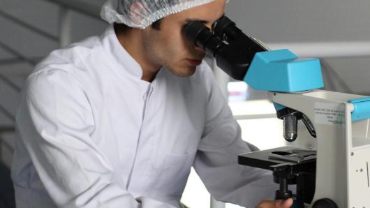 Scientist looking into microscope.